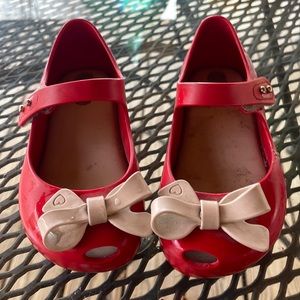 Mimi melissa shoes for little girls , red in color with tan bow.